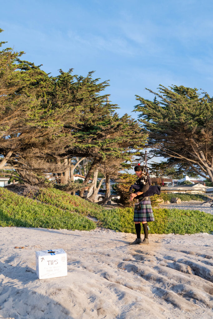 Bagpipe player playing music on Carmel Beach in Carmel by the Sea California
