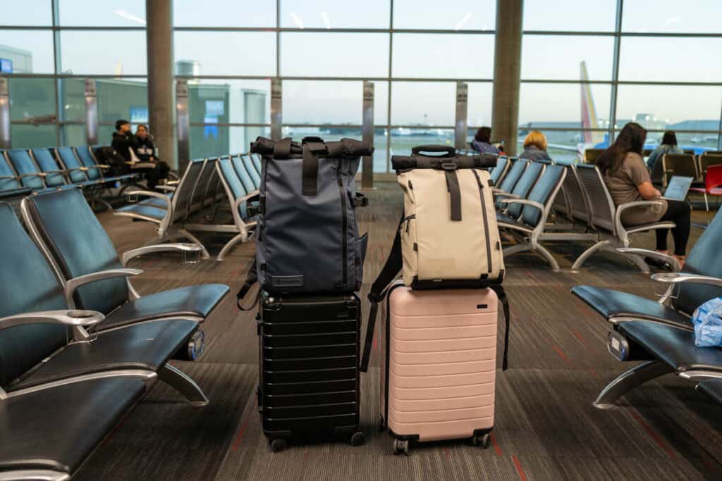 Two Away brand carry-on suitcases with WANDRD brand photography backpacks on top.